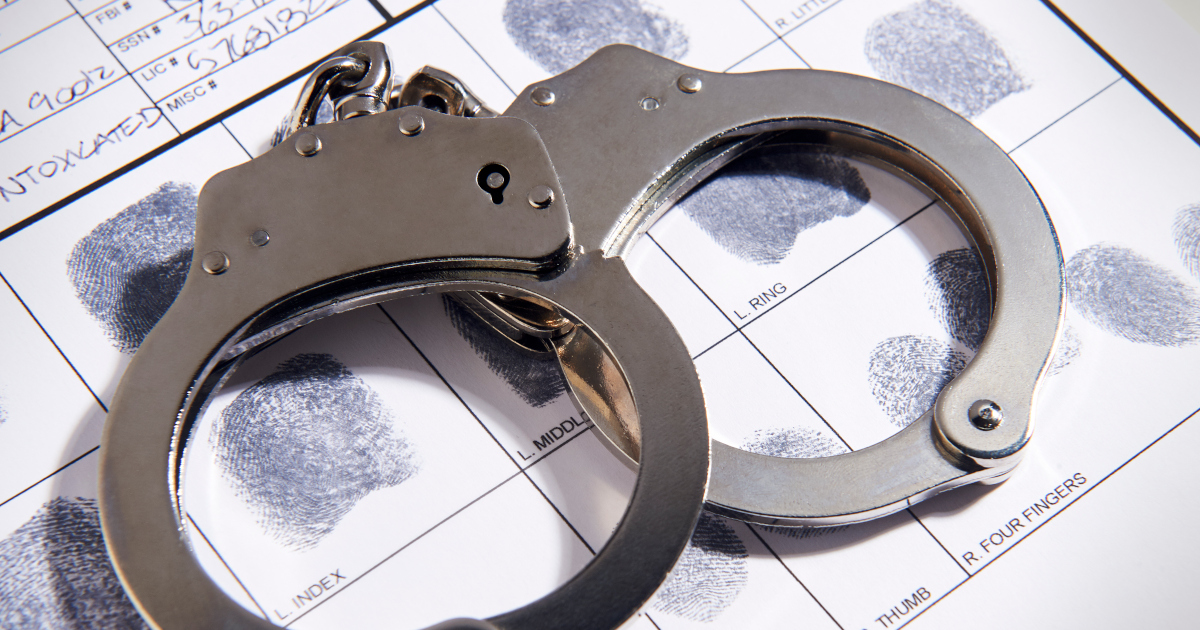 Handcuffs Atop A Fingerprint Card And An Intake Form