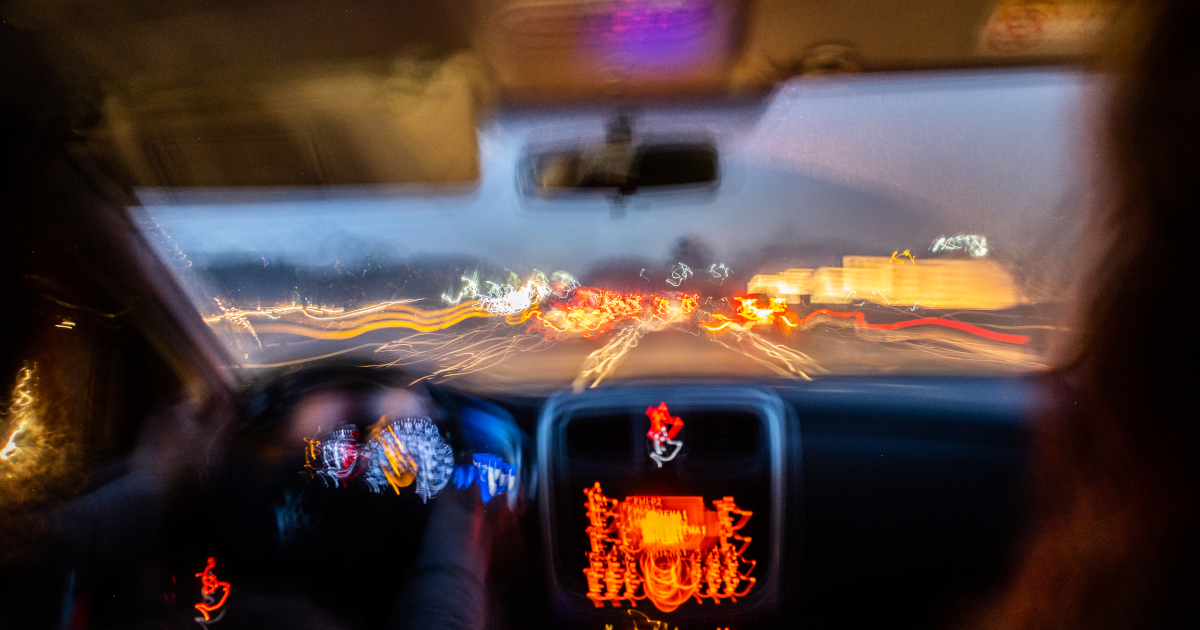 Scene From Inside A Car Driving Down A Highway With Oncoming Headlights Blurred