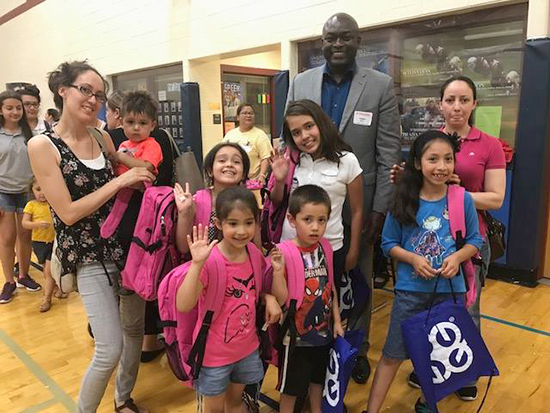 Odalo Ohiku poses with students at the donation event in Milwaukee.