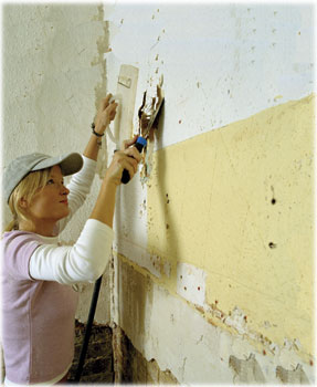 worker scraping walls