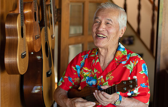 elderly man laughs playing guitar