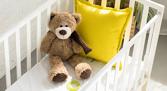 teddy bear in crib