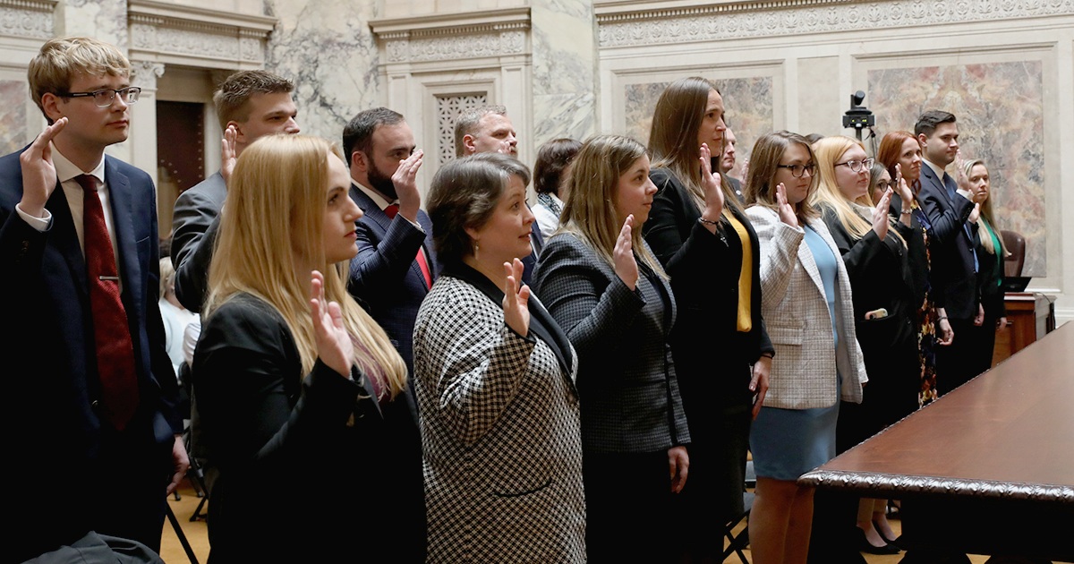 a group of people with hands raised to take an oath