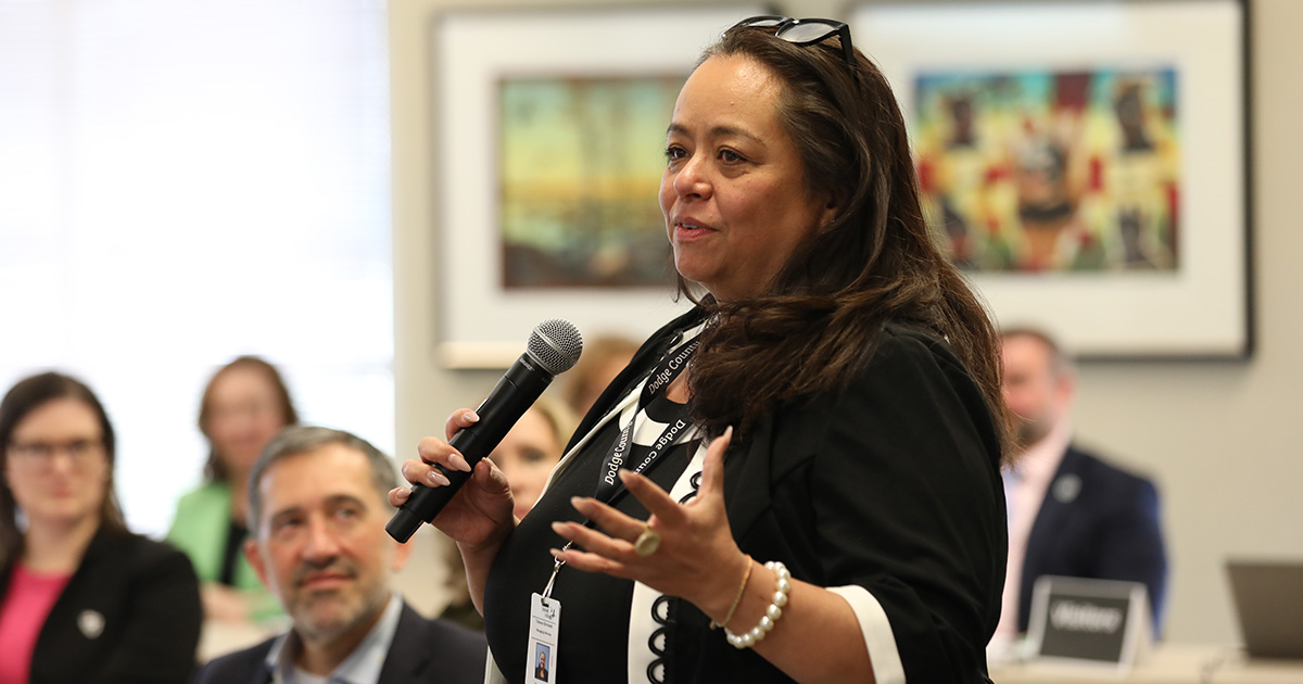 a woman standing and talking into a microphone