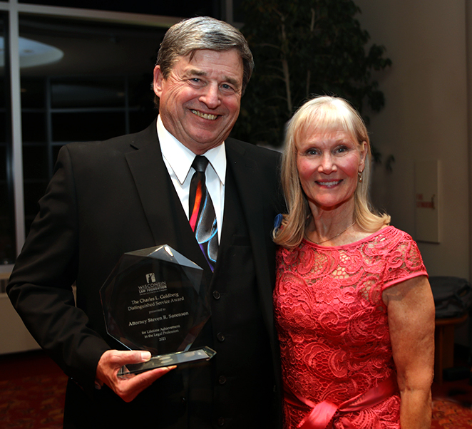 Steven Sorenson holding an award and standing with Kathleen Grant