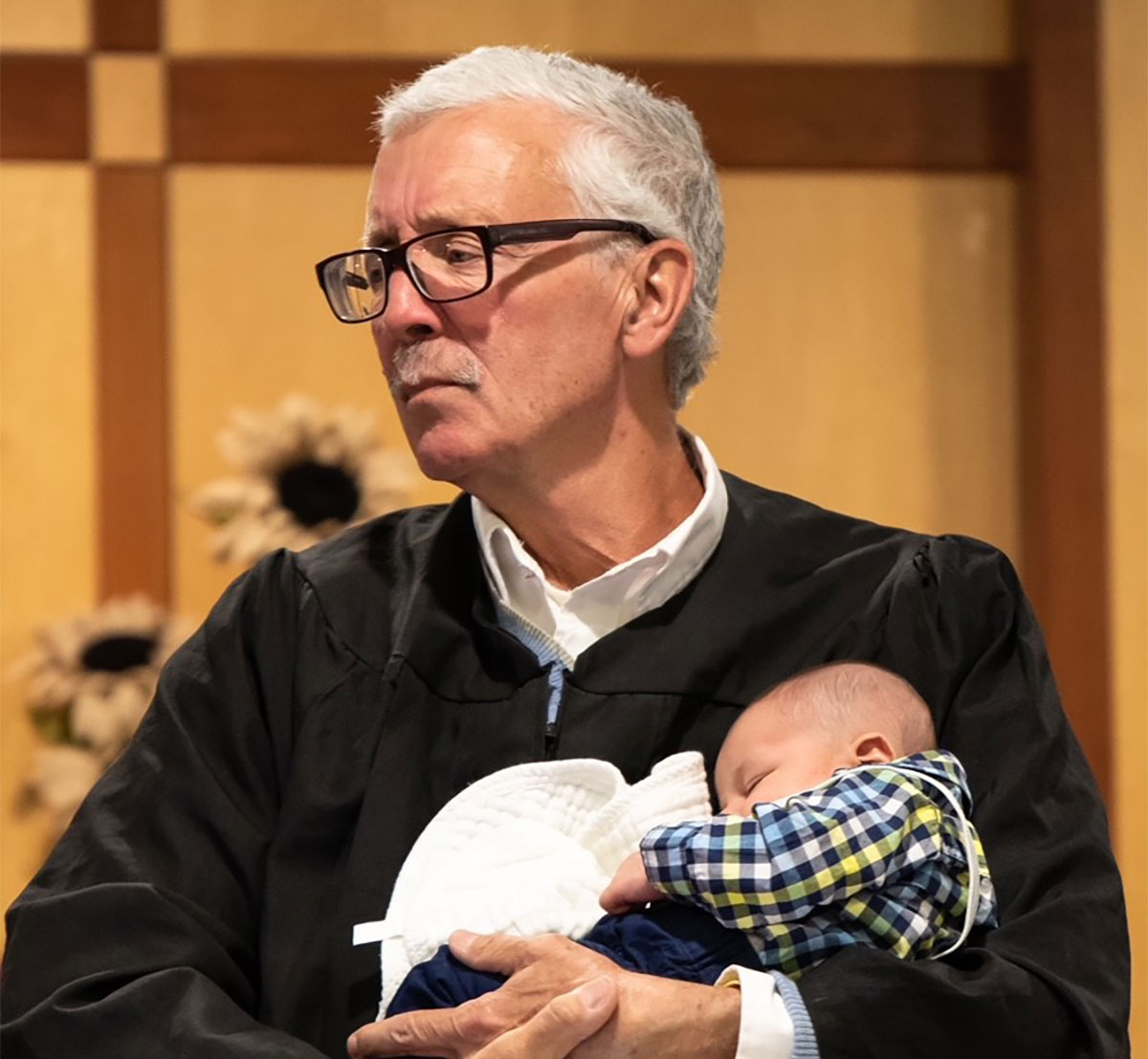 Judge Christopher Foley holds baby during an adoption proceeding