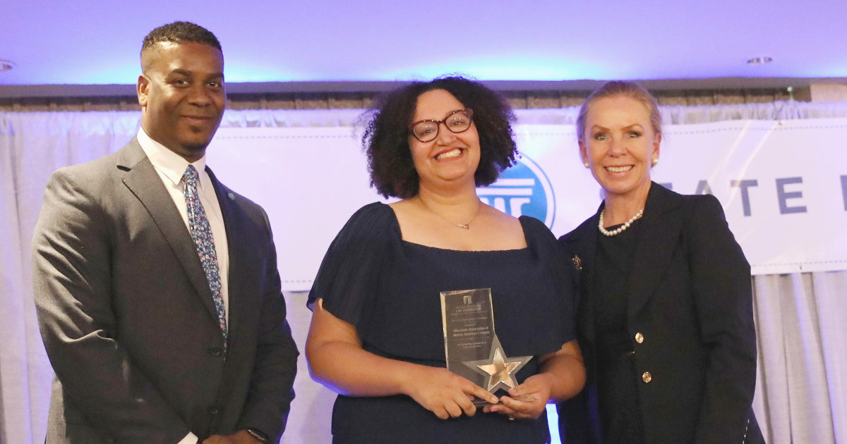 Amber Raffeet August holding the Gordon Sinykin Award, with Saveon Grenell and Chief Justice Annette Kingsland Ziegler