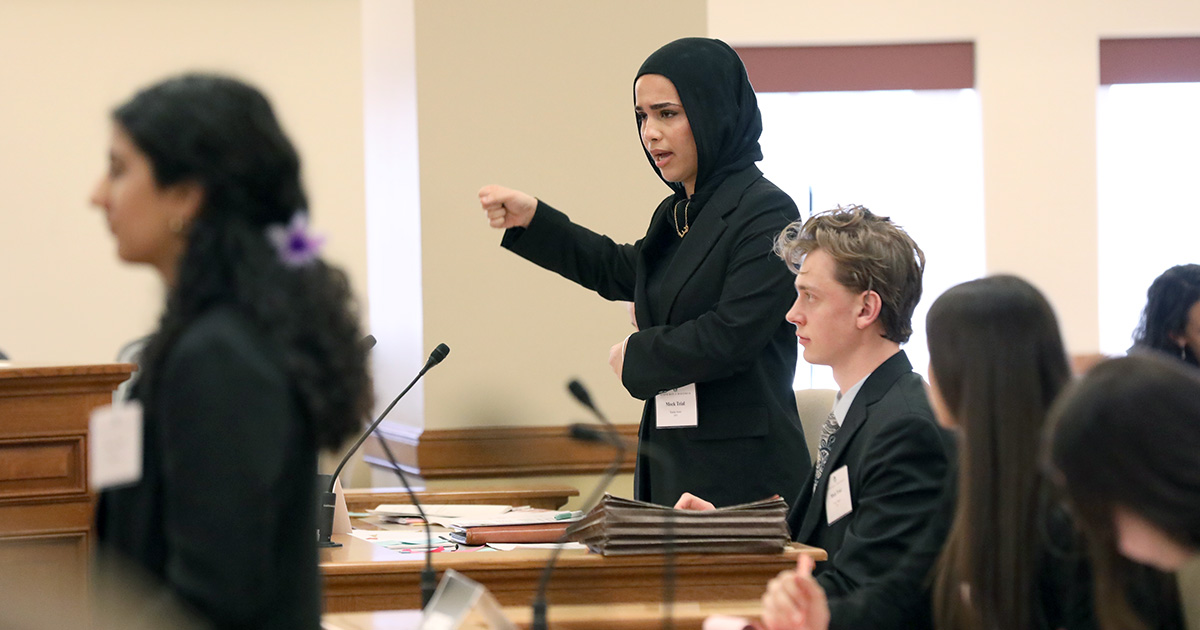 a high school student standing up, hand raised