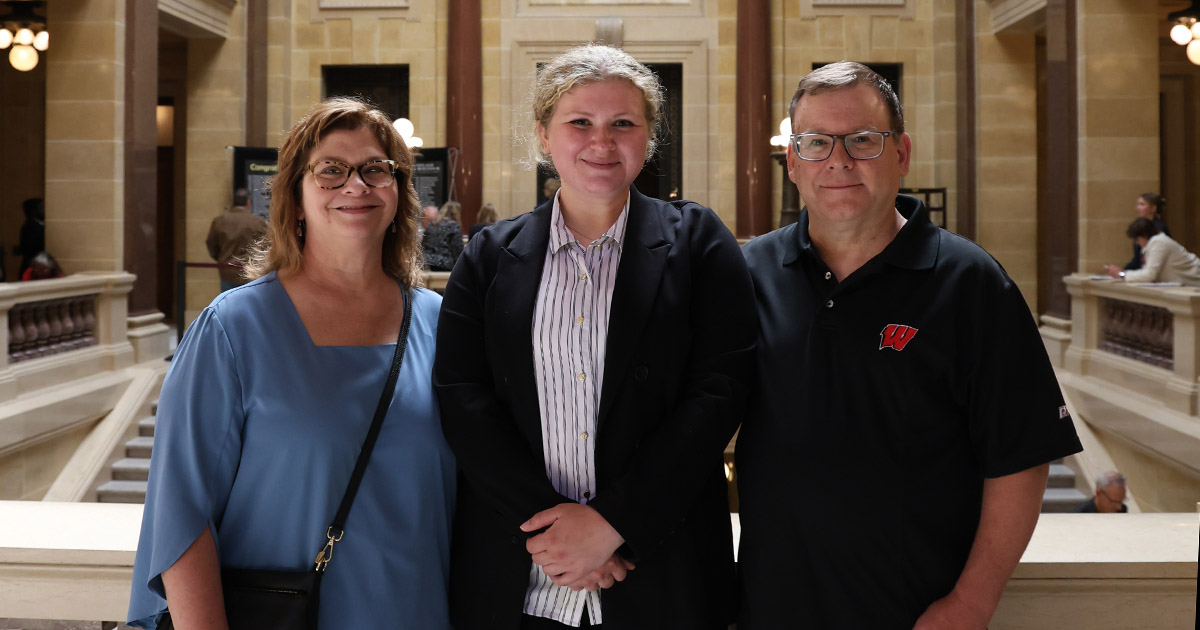 three people smile at the camera