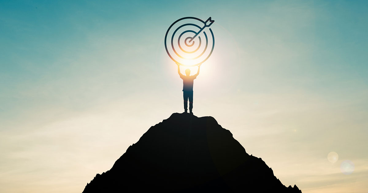 professional holds target atop a mountain