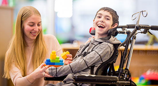 child in wheelchair with caregiver