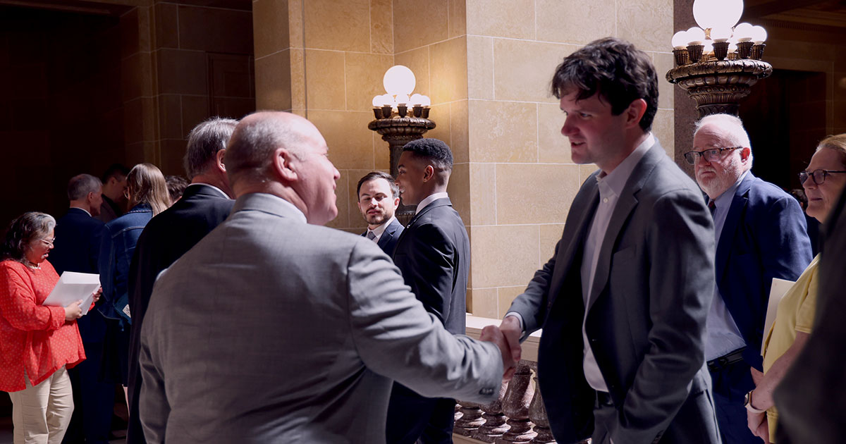 two men shake hands