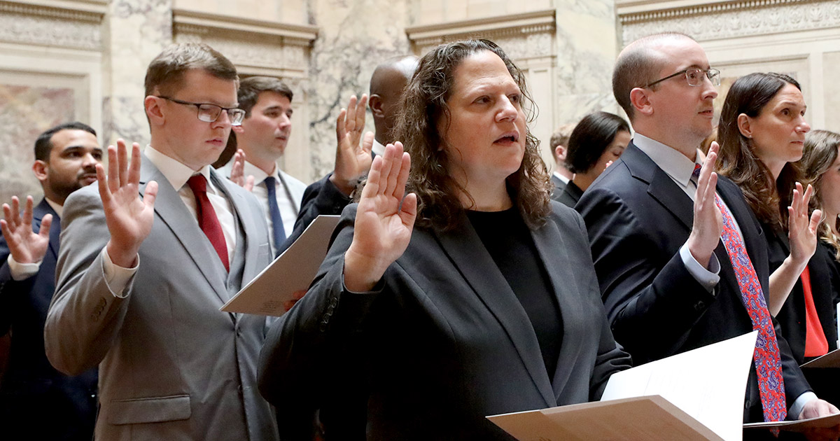 a group of people with hands raised to take an oath