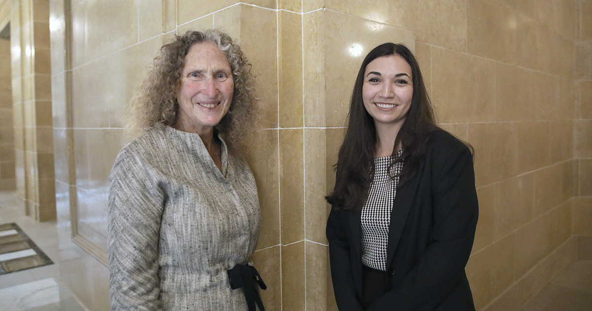 two women smile at the camera in a corridor in the Wisconsin State Capitol