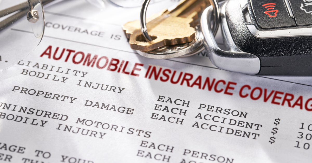 A Car Key And Fob Lying Across An Auto Insurance Policy Summary