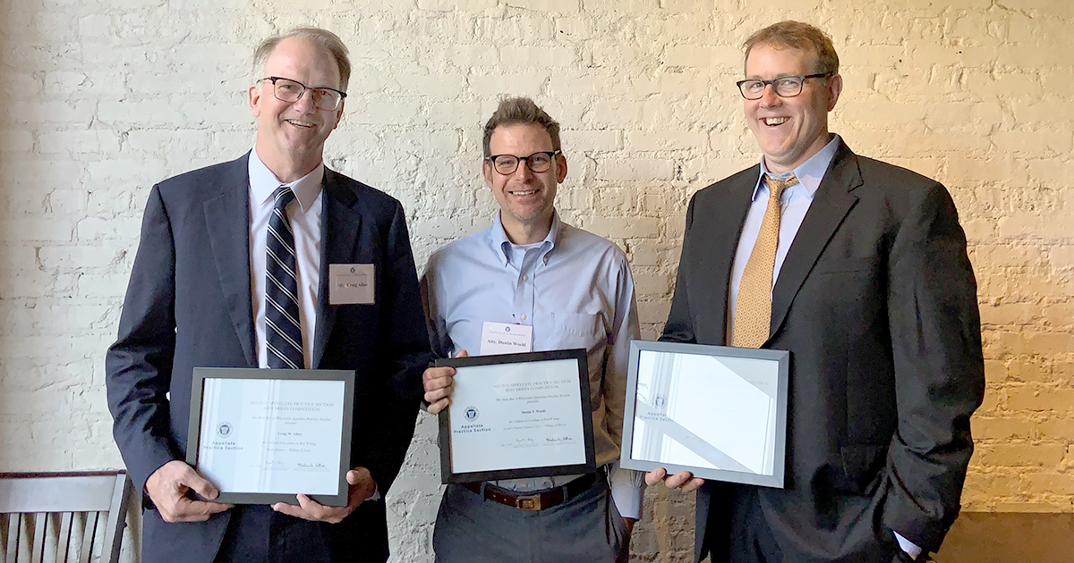 Three of four winners standing holding certificates