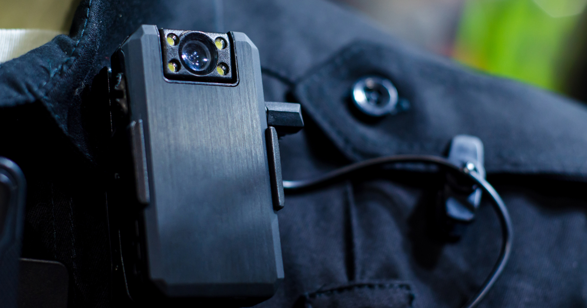 Closeup Of A  Camera Mounted To A  Police Officer’s Uniform, Just Below The Collar