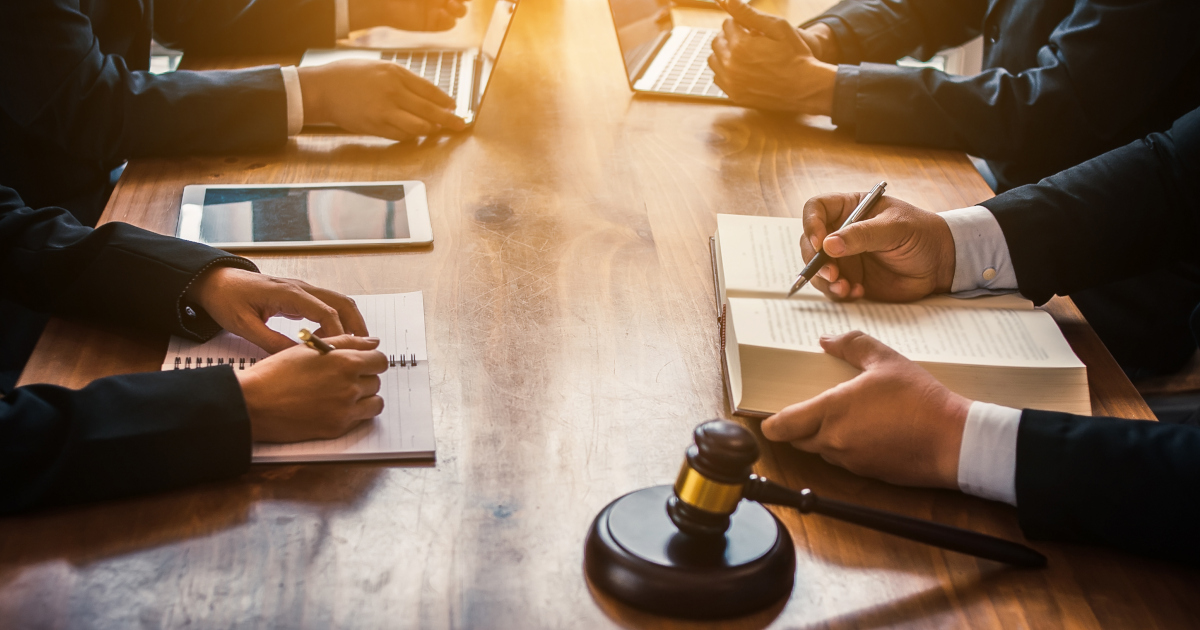 Business People Seated Around A Table And A Judges Gavel