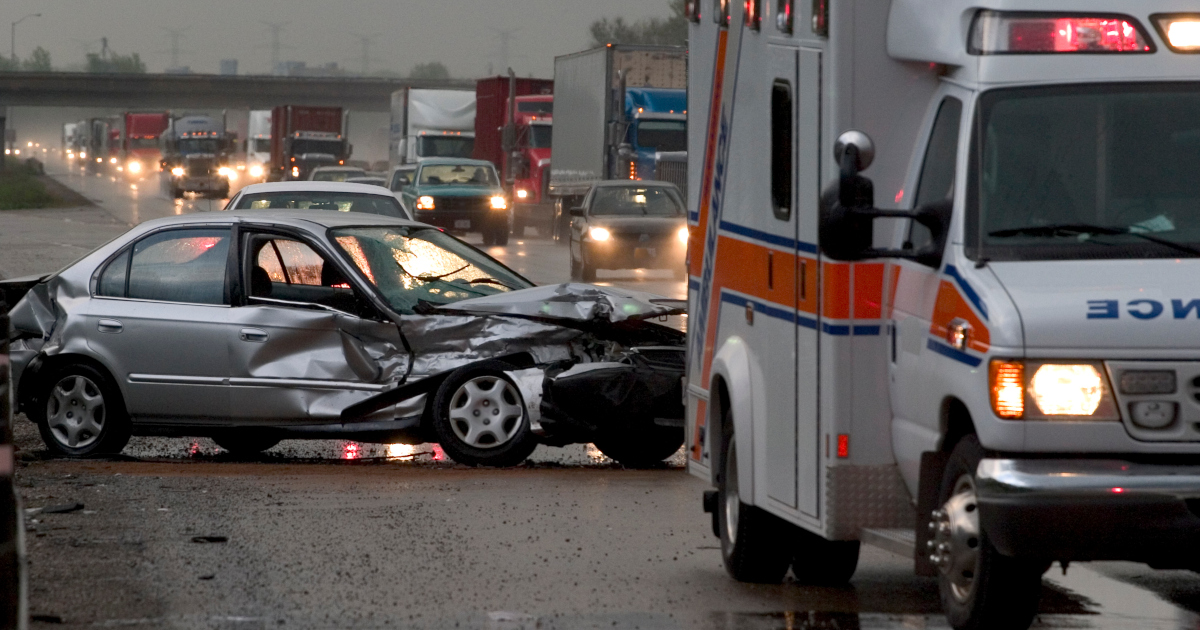 An Ambulance Next To A Wrecked Automobile