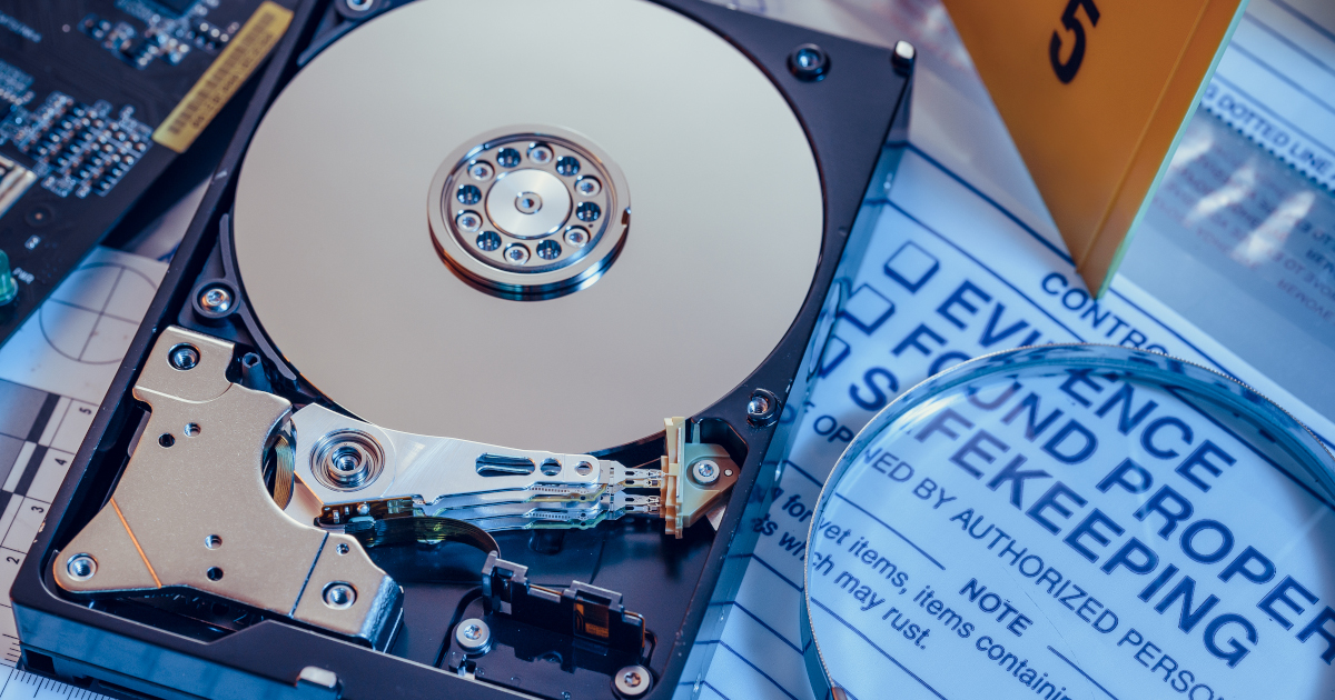 A Computer Hard Drive, Lying Next To A Magnifying Glass, Atop a Form That Reads Evidnece Found Property Safekeeping