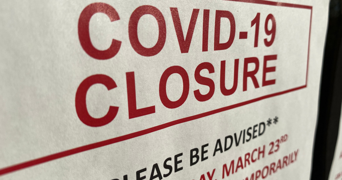 Red-lettered Sign Posted In Shop Window That Reads Covid-19 Closure
