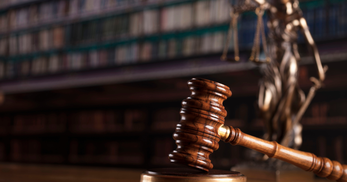 Judge’s Gavel and Scales Of Justice On Conference Table in Law Library