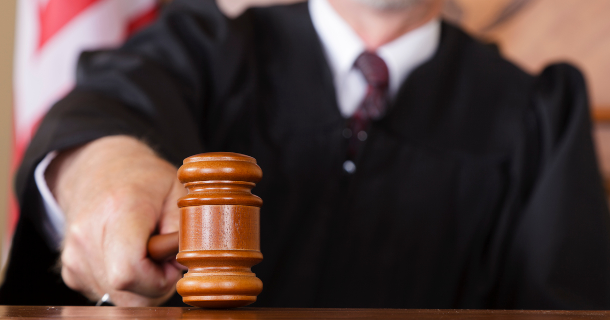 Close Up View of A The Head Of A Wooden Gavel As A Judge Strikes It Against The Dais