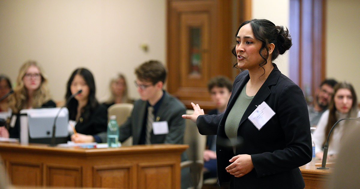 Talani Silpao stands in the well and gestures toward the prosecution table