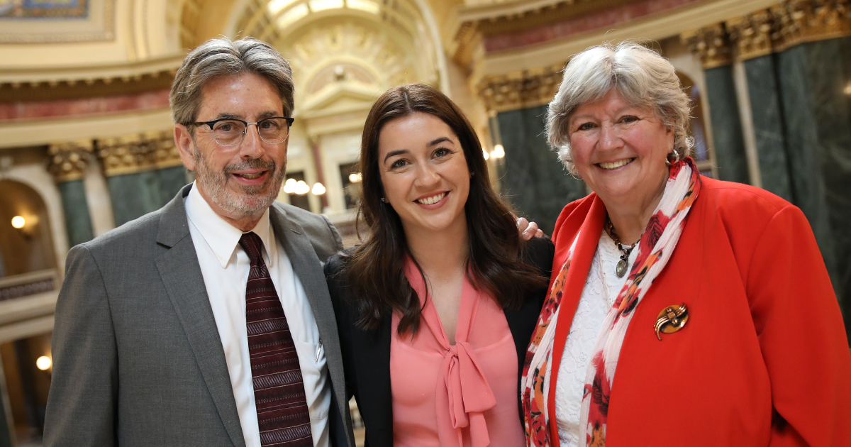 Three people smiling at the camera