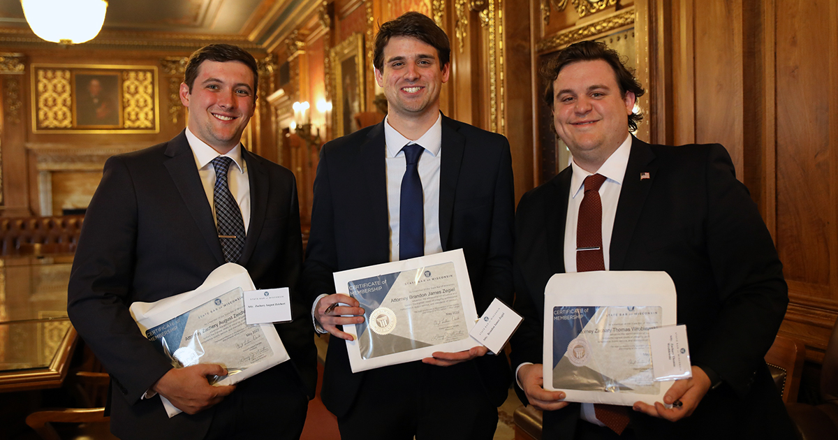 three men smile at the camera