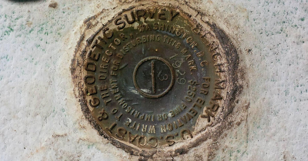 a circular rusty metal disc that marks the base of the Jupiter Inlet Lighthouse in Florida
