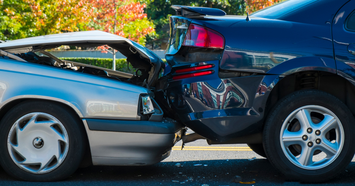 A Silver Sedan, Its Hood Crumpled, Has Slammed Into The Back Of A Blue Sedan