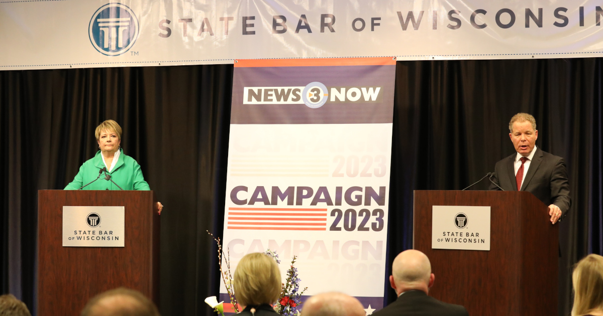 Judge Janet Protasaywitz, Standing Behind A Lectern On The Left, and Justice Daniel Kelly, Standing Behind A Lectern On The Right, Beneath A Banner That Reads State Bar of Wisconsin
