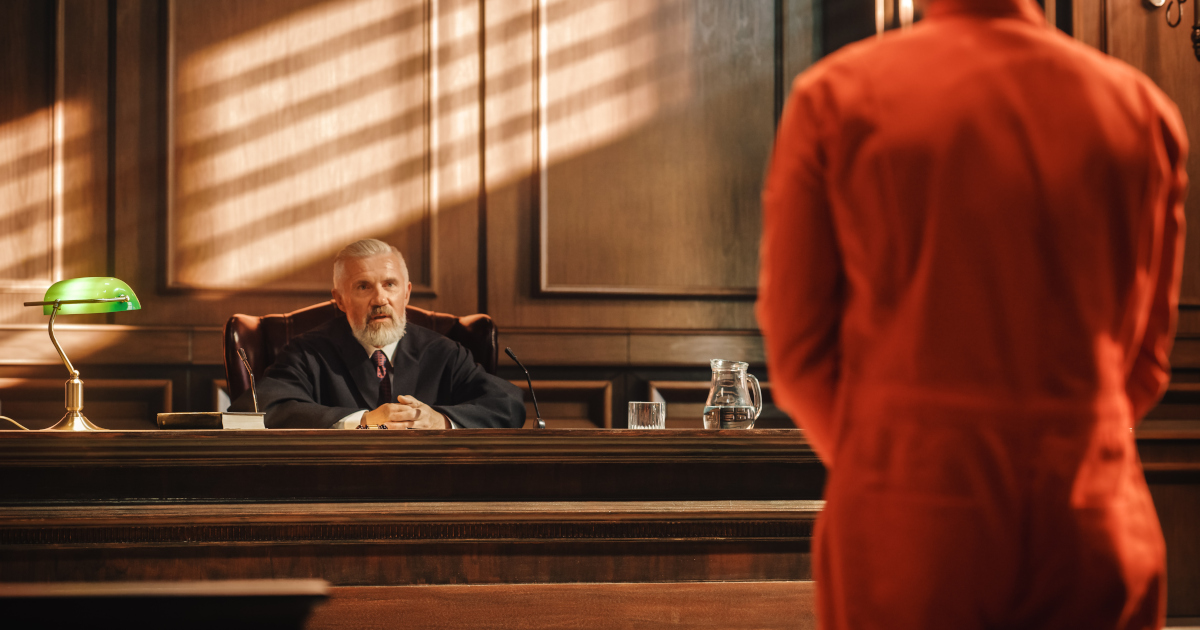 Defendant in Orange Jail Jumpsuit Standing Before A Judge