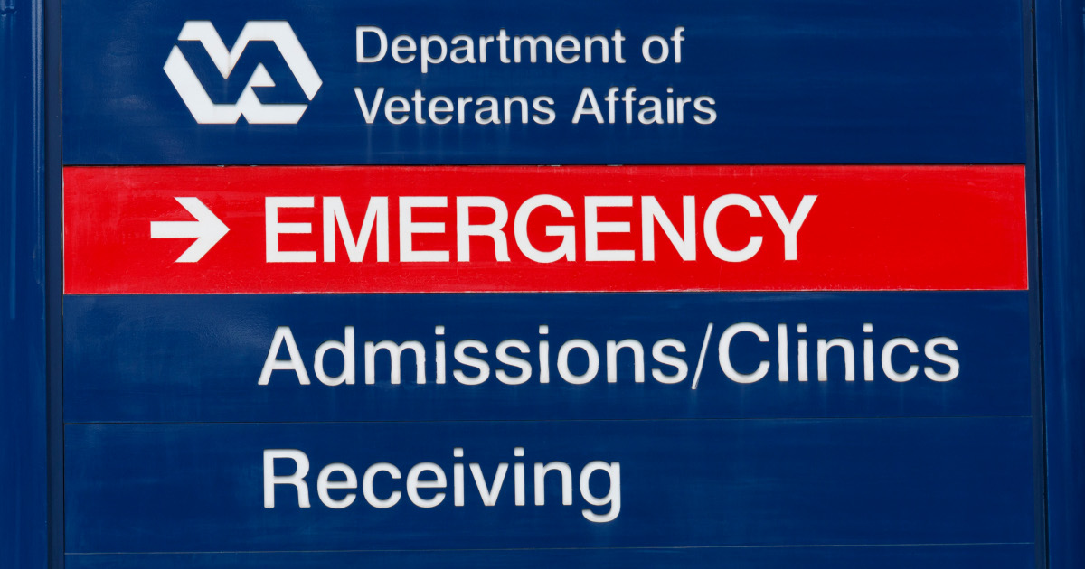 A Blue Sign That Reads Departmnet of Veterans Affairs Along The Top With Emergency, Admissions and Clinics, And Receiving In Separate Rows Beneath