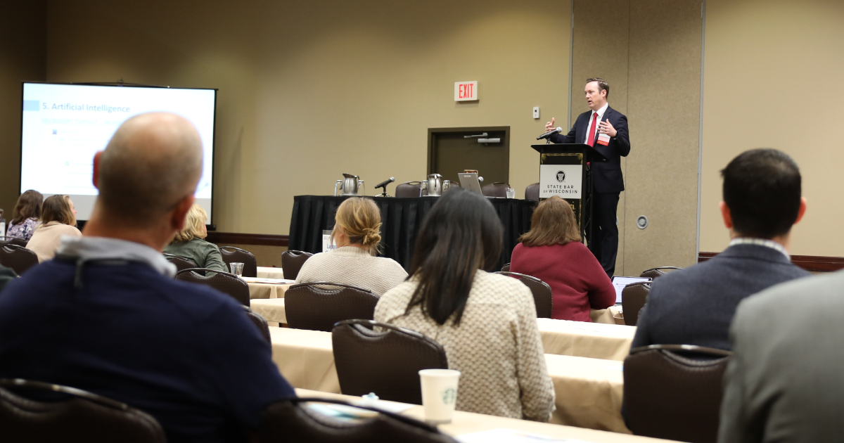 A man stands at a podium at a CLE session