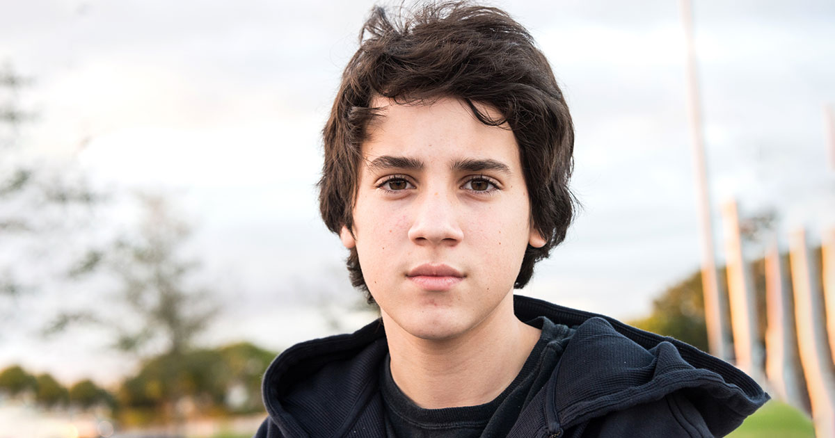 teenager looks pensively at the camera