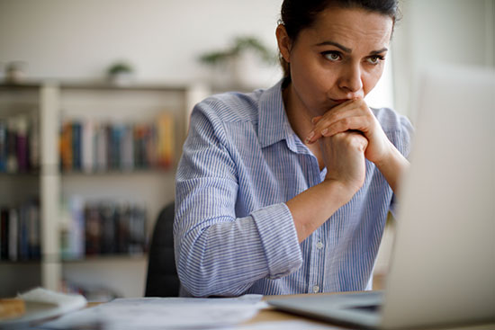 woman contemplating computer