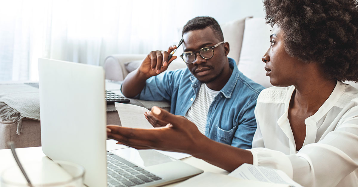 anxious couple looks at laptop