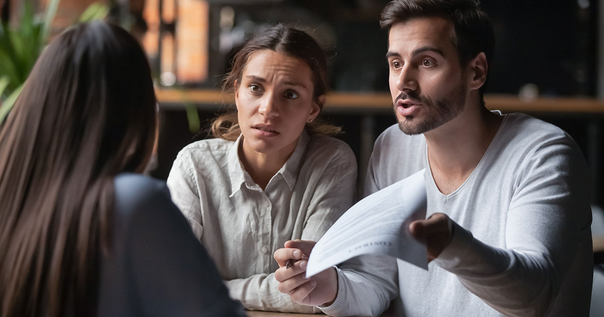 couple looking upset over paperwork