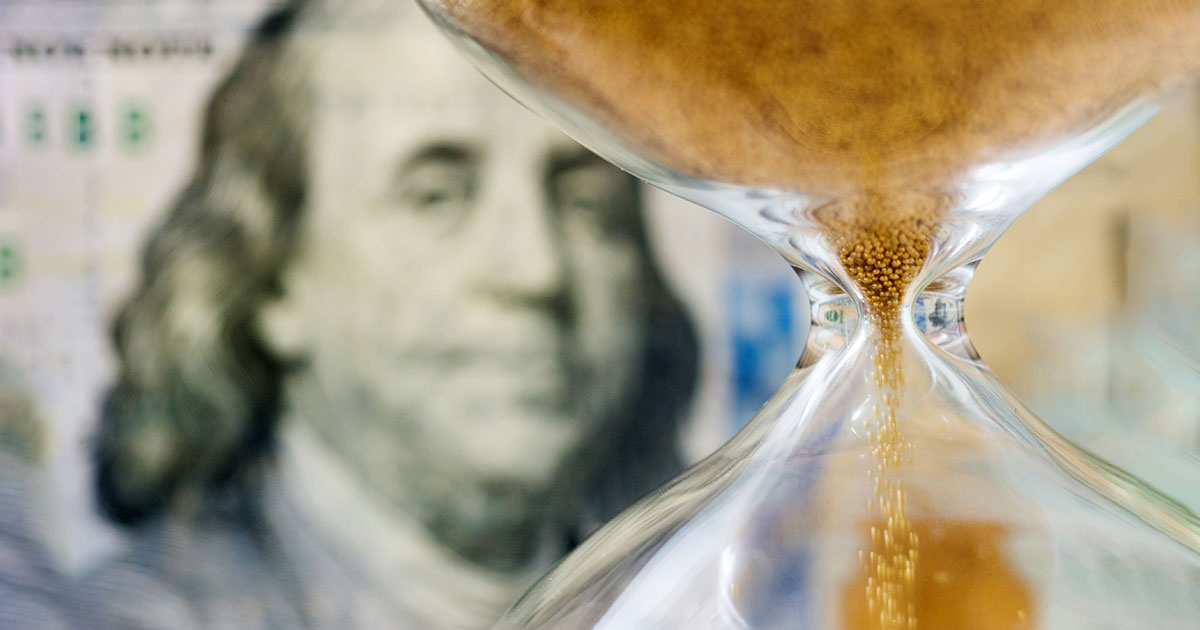 hourglass with money in background