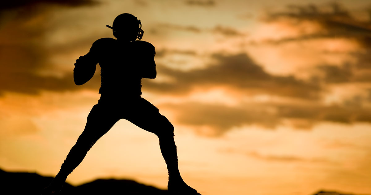 silhouette of a quarterback holding a football