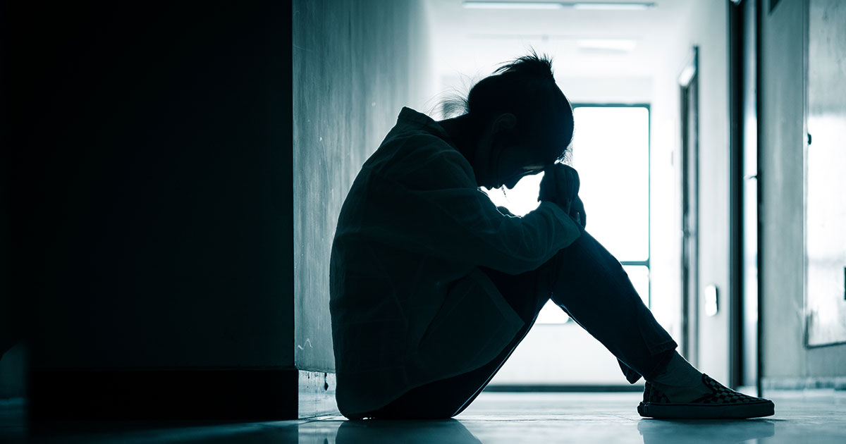 person sitting on floor looking depressed or exhausted