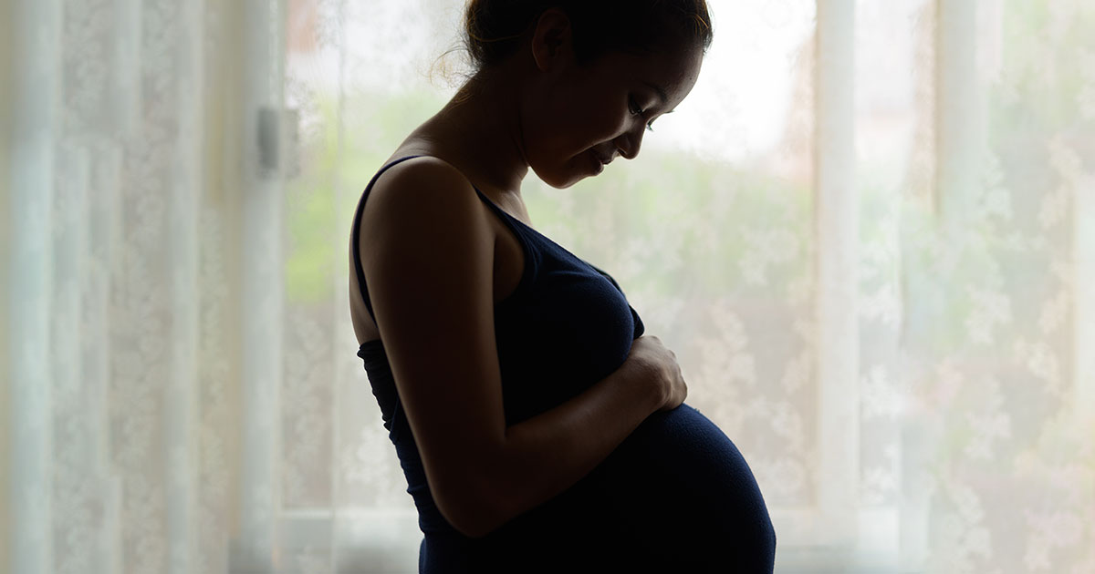 pregnant woman holds belly