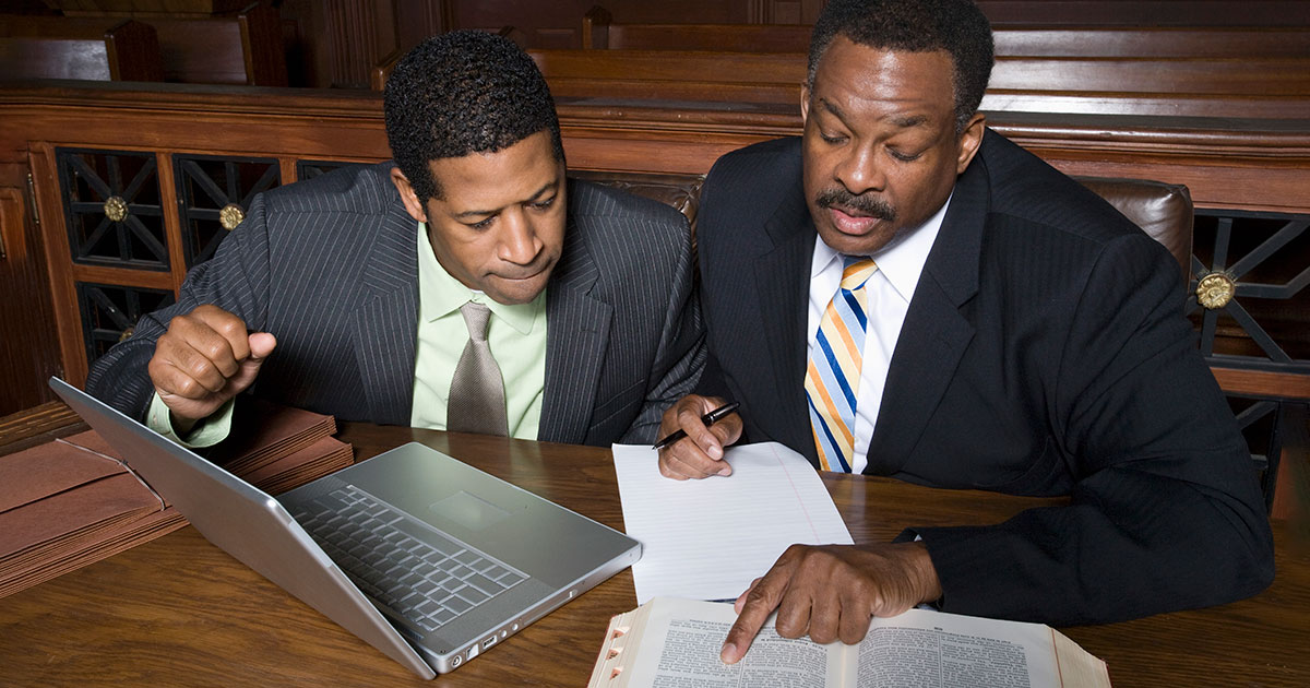 attorneys looking through a document and book