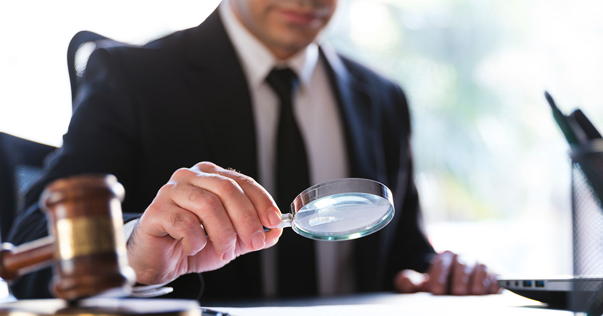 attorney examining document with magnifying glass