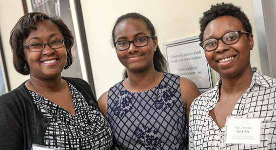 Program participant Joy Mitchell, 15, center, stands with her mother, Jackie, left, and her new attorney mentor, Jourdan Glenn, right.