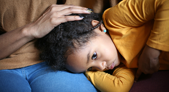 young girl being comforted by mother