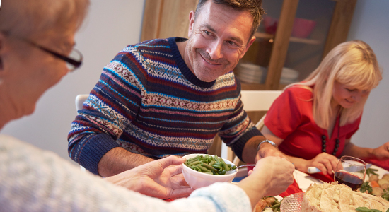 elderly mother and son at family holiday dinner talk
