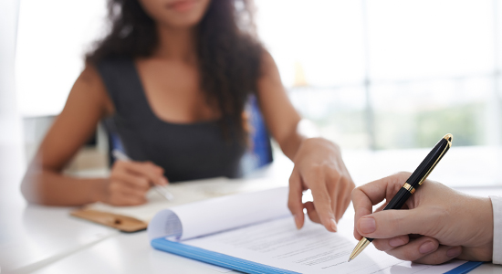 signing document with lawyer in background